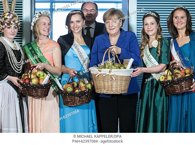German Chancellor Angela Merkel stands with a basket of apples next to Minister of Agriculture Christian Schmidt in the Federal Chancellery in Berlin,  Germany
