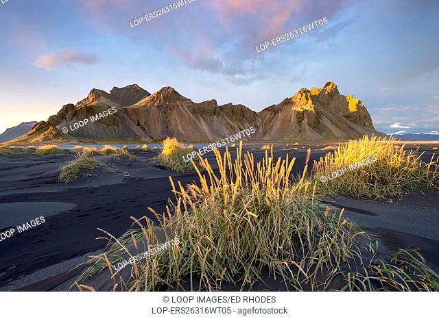 Black volcanic sand dunes below Vestrahorn mountain at sunset