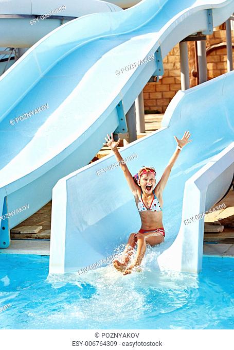 Child on water slide at aquapark. Summer holiday