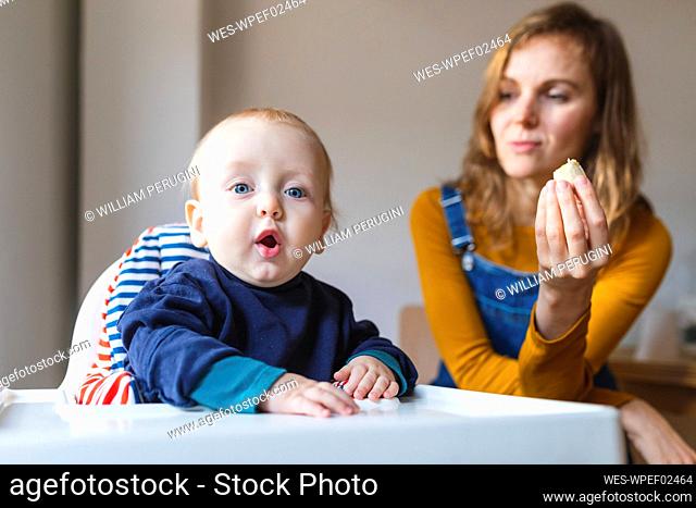 Portrait of baby boy with his mother siting in highchair