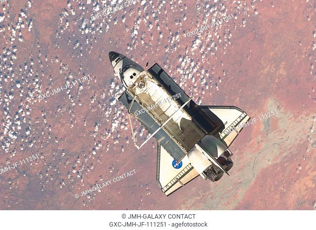 Backdropped by a colorful part of Earth, the space shuttle Endeavour is featured in this image photographed by an Expedition 22 crew member on the International...