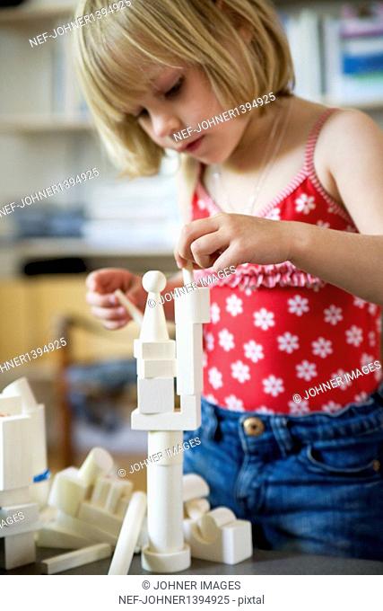 Girl playing with wooden blocks