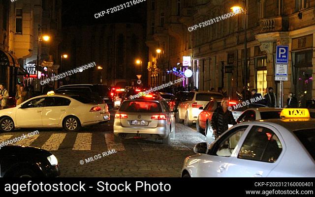 Dozens of taxi cars and noisy people on the streets in front of the night bars in the Old Town on the night of December 16, 2023