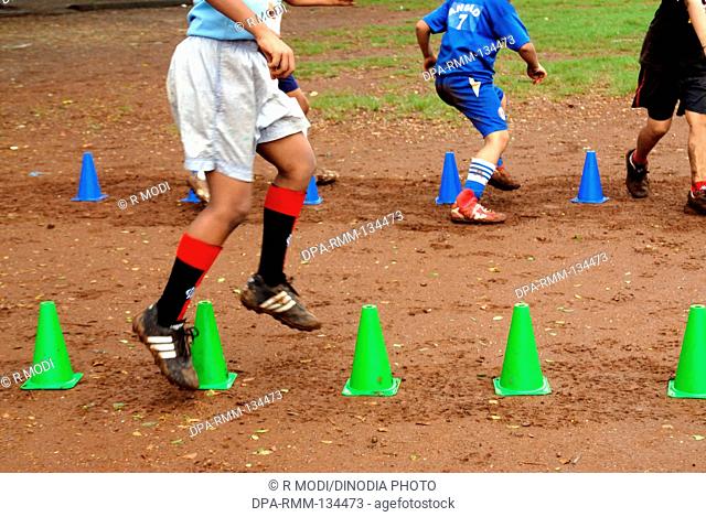 South Asian Indian boys playing , practice , enjoying with foot ball during monsoon season , India NO MR