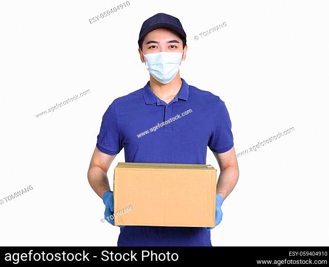 Young courier, employed wearing blue clothes and hats, protective masks and gloves to protect himself, delivering packages during the covid-19 epidemic