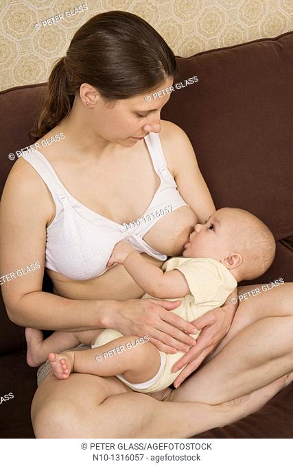 Mother breast-feeding her six-month old son