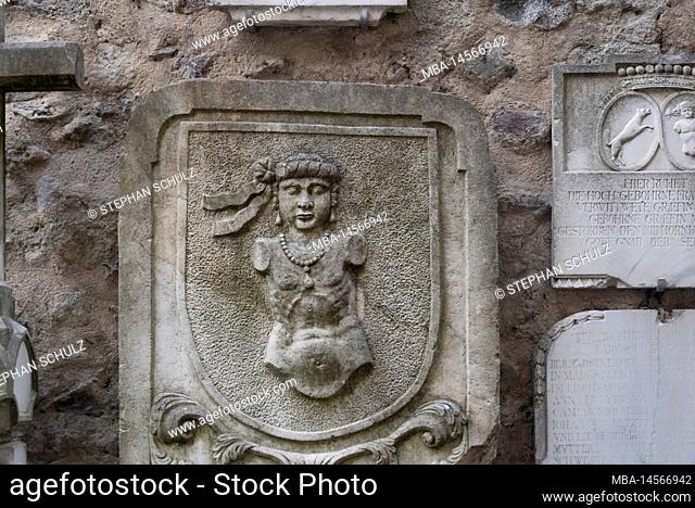 Historical tomb slab on the exterior façade of the parish church of St. Nicholas, Merano, South Tyrol, Italy
