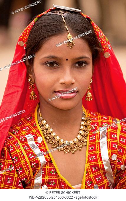 Portrait einer jungen Frau in der typischen farbenfrohen Tracht der Rajasthanis beim Kamel- und Viehmarkt Pushkar Mela in Pushkar, Rajasthan, Indien