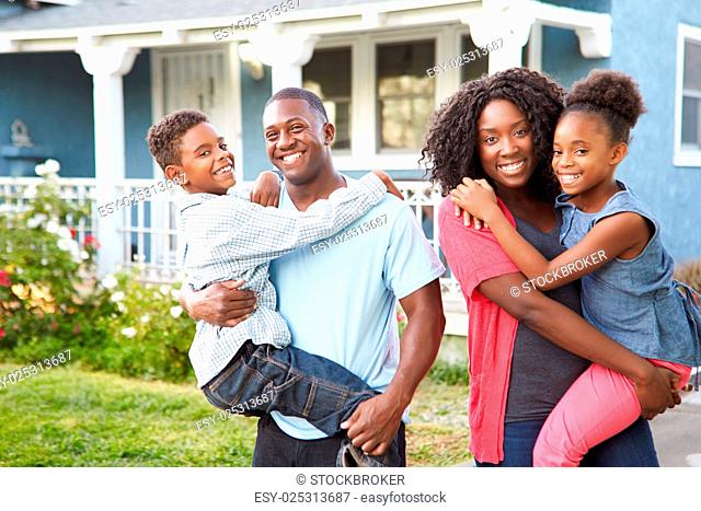 Portrait Of Family Outside Suburban Home
