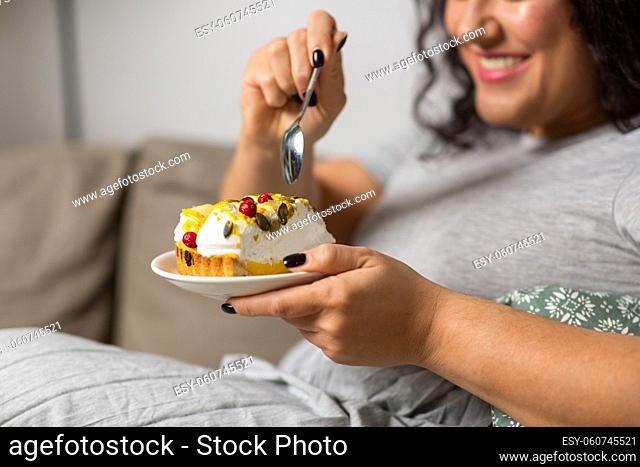 close up of smiling woman eating cake at home