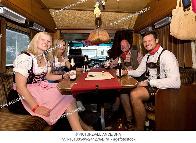 02 October 2018, Baden-Wuerttemberg, Stuttgart: Kathrin (l-r), Franziska, Markus and May from Bielefeld are sitting in a camper van at the Cannstatter Wasen...
