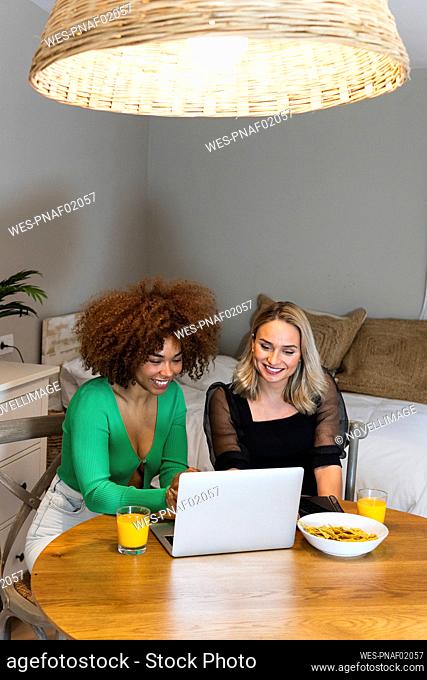 Multi-ethnic female coworkers using laptop at home office