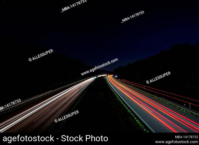 Lighttrails of a traffic motorway from the cars front and headlights, passing fast the point ov view