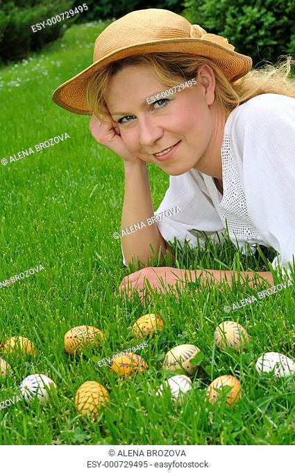 Young woman and easter eggs on grass - Easter time