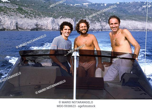 The comedian Beppe Grillo, the Tv host Pippo Baudo and the actor Massimo Troisi having a trip on a motorboat. 1981