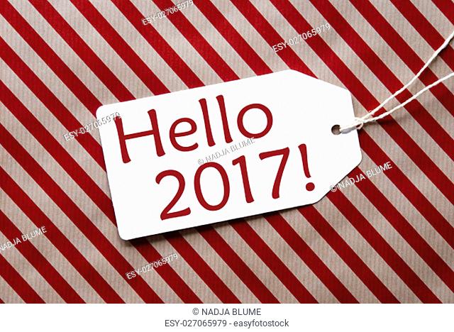 One Label On A Red And Brown Striped Wrapping Paper. Textured Background. Tag With Ribbon. English Text Hello 2017 For Happy New Year Greetings