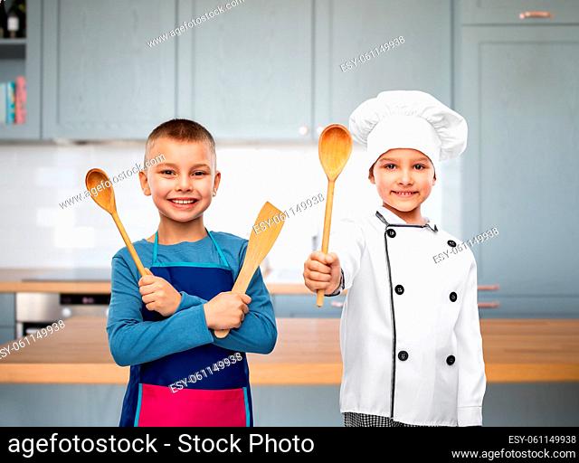 happy children with spoon and spatula in kitchen
