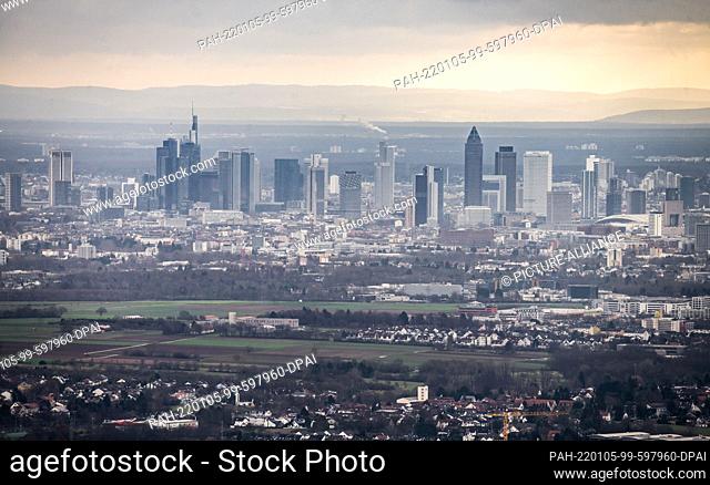 05 January 2022, Hessen, Falkenstein: Frankfurt's skyscrapers tower high into the sky as you look down from the heights of the Taunus onto the Maine plain