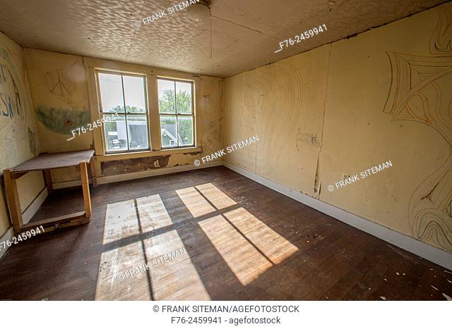 Large empty room in an abandoned house, with graffiti like drawings on the walls