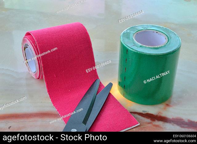 tape bandages with black scissors green and magenta tape application against pain