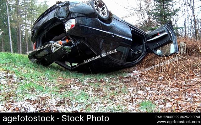 09 April 2022, Lower Saxony, -: A car has overturned in heavy hailstorm and lies upside down next to the federal highway 214 between Ankum and Schwagstorf in...
