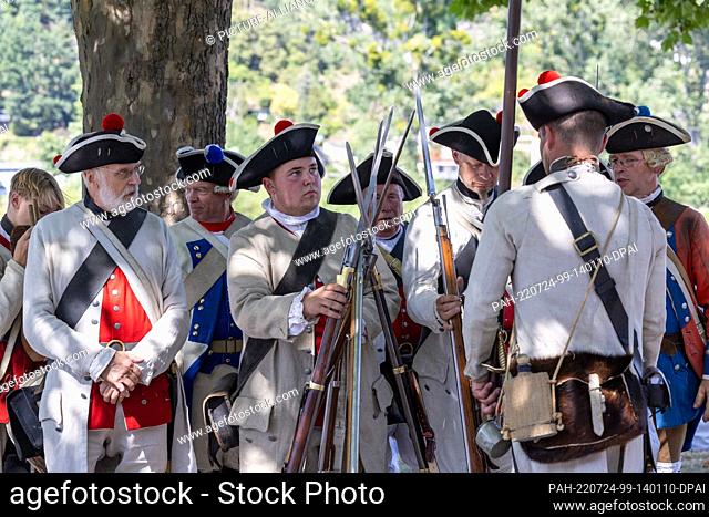 24 July 2022, Saxony, Pirna: Several soldiers take a rest under a tree, setting up arms. As part of the 300th anniversary of the birth of the Italian painter...