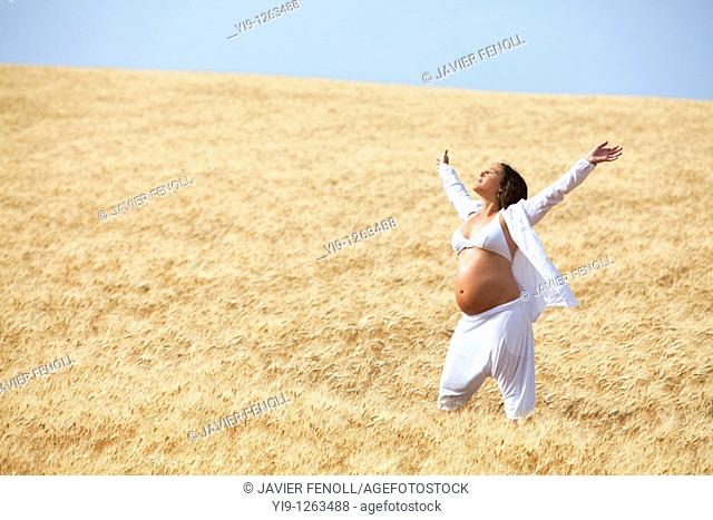Pregnant woman relaxing in field