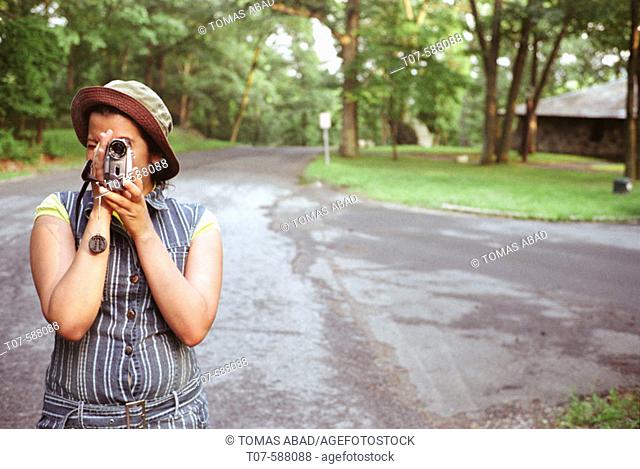 Latino woman holding video camera