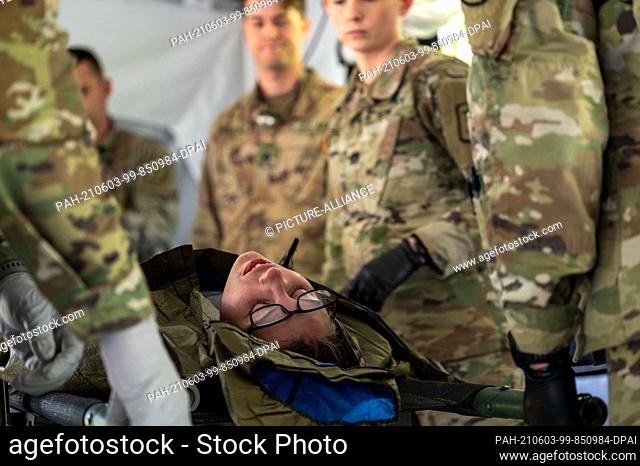 03 June 2021, Rhineland-Palatinate, Baumholder: US soldiers attend to a female soldier with a gunshot wound during an exercise