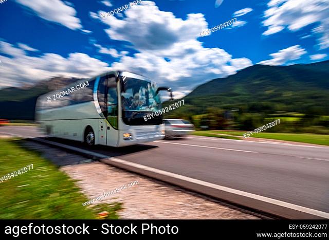 Tourist bus traveling on the road in the background the Dolomites Alps Italy. Warning - authentic shooting there is a motion blur