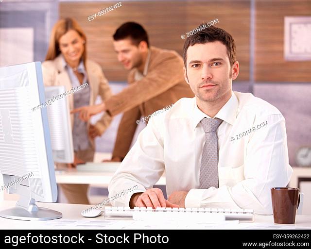 Young handsome businessman sitting at desk at further education training