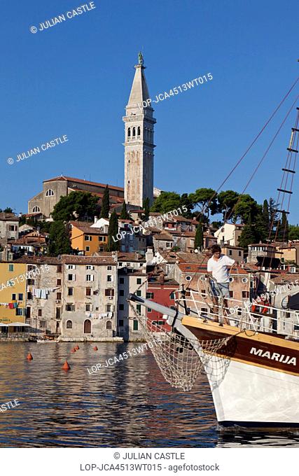 Croatia, Istria, Rovinj. A sailboat enters Old Town waterfront at Rovinj