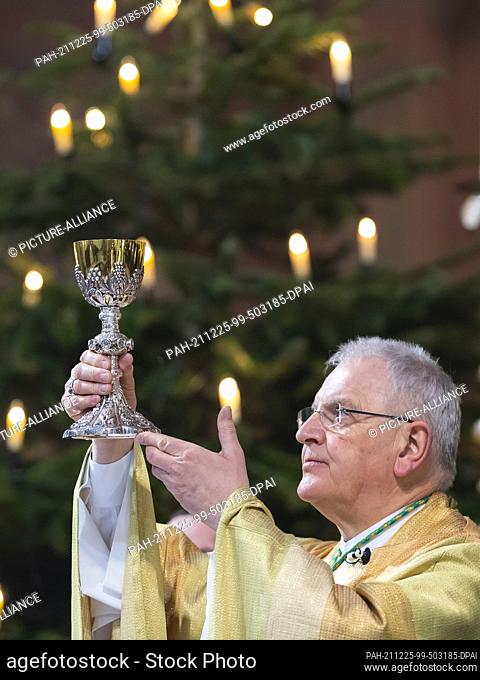 25 December 2021, Saxony, Dresden: Heinrich Timmerevers, Bishop of the Diocese of Dresden-Meissen, holds the chalice during the Christmas service in the...