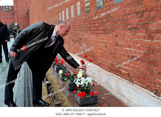 At the Kremlin Wall in Moscow, Expedition 3940 Flight Engineer Oleg Artemyev of Roscosmos lays flowers in a tribute to Russian space icons who are interred...