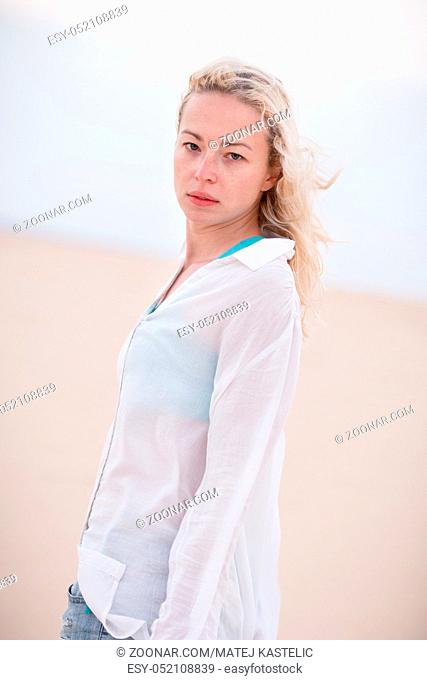 Beautiful sensual woman alone at beach. Melancholic vintage mood. Summer moved on