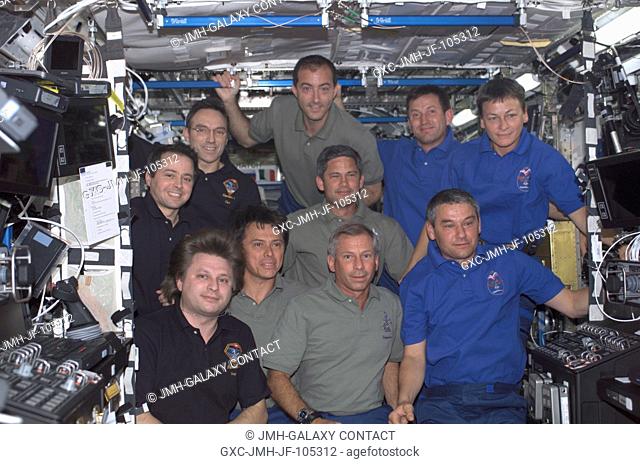 The Expedition Four (dark blue shirts), STS-111 (green shirts), and Expedition Five (medium blue shirts) crews assemble for a group photo in the Destiny...
