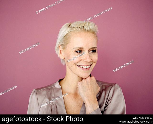 Close-up of smiling businesswoman looking away against purple background