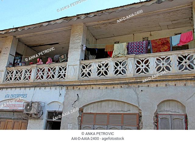 Washing line and Muslim women on balcony of apartment in Stone Town, Zanzibar, Unguja Island, Tanzania
