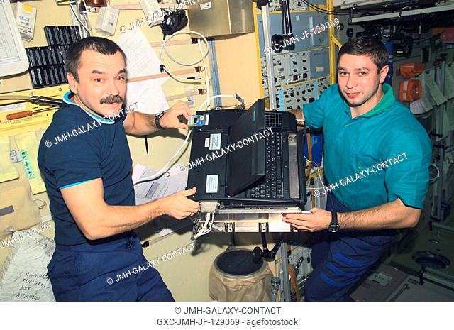 Cosmonaut Mikhail Tyurin (left), Expedition Three flight engineer, and Soyuz Taxi crewmember, Flight Engineer Konstantin Kozeev work in the Zvezda Service...