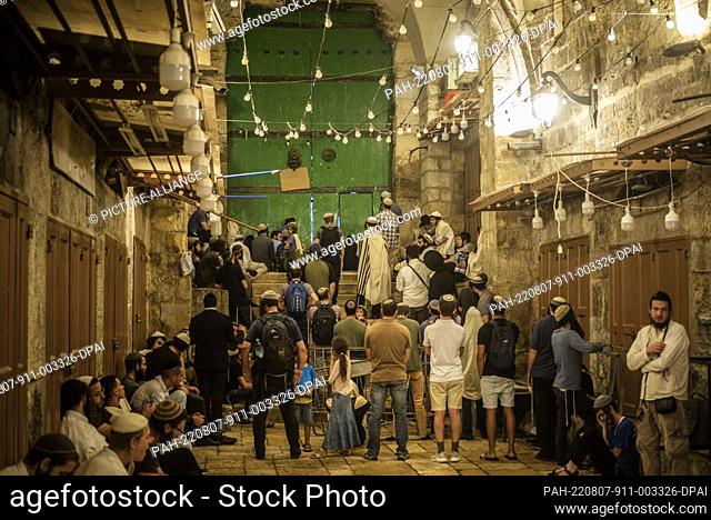 07 August 2022, Israel, Jerusalem: Jews pray at the door of the Al-Aqsa Mosque compound in the old city of Jerusalem during the holy day Tisha B'Av