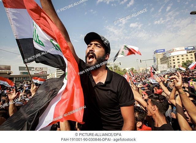 01 October 2019, Iraq, Baghdad: Protesters shout slogans during an anti-government demonstration against the provision of jobs and the alleged government...
