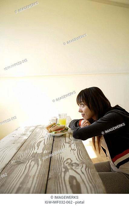 Young woman sitting with breakfast