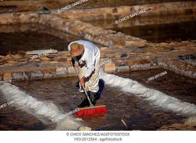 A man cleans a salt flat using a scrub brush at the Salinas de Hortales salt mine in Prado del Rey, Cadiz, Andalusia, Spain, July 16, 2013