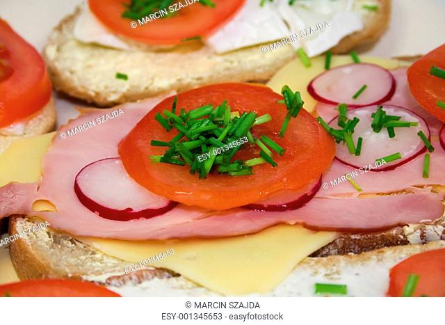 Tomato radish, ham, cheese and chive on sandwich
