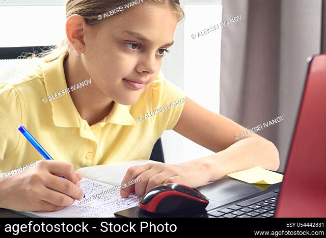 Portrait of a cute girl at the laptop engaged in distance learning