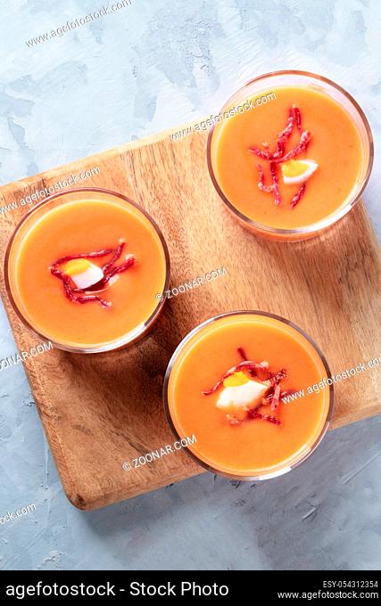 Salmorejo, Spanish cold tomato and bread soup, served in glasses, overhead close-up shot with a place for text