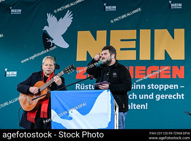 25 November 2023, Berlin: A man with a guitar plays before the start of a peace demonstration by various initiatives on the Platz des 18