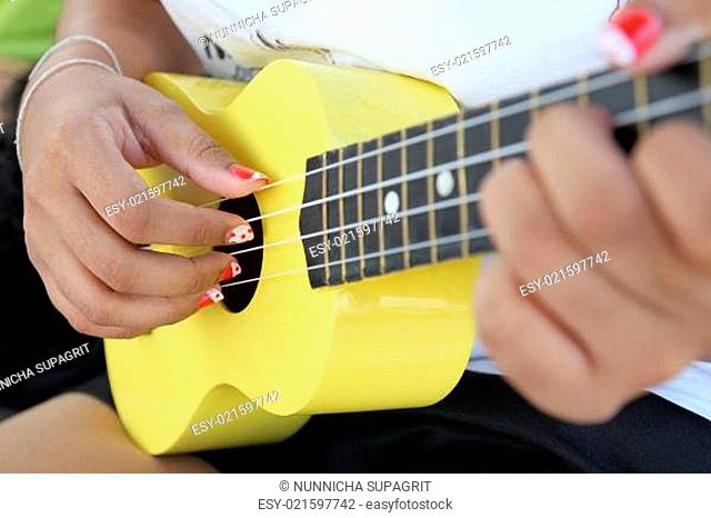 Closeup of a woman playing ukulele