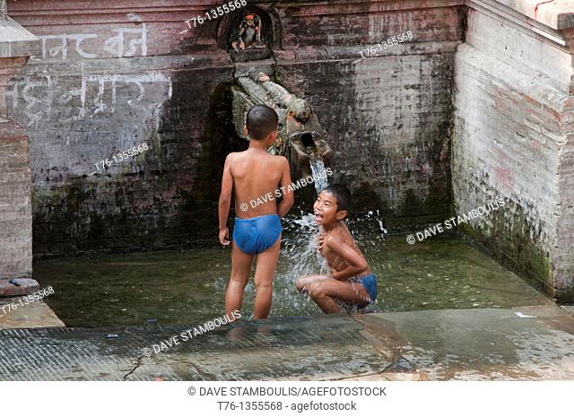boys having a bath and playing at a fountain in Kathmandu, Nepal