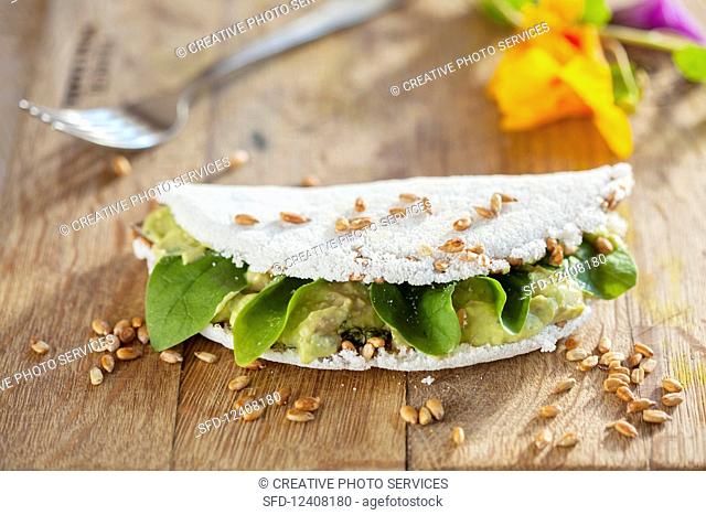 Tapioca filled with guacamole and garnished with activated sesame seeds (Brazil)